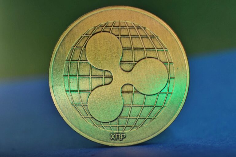 gold-xrp-coin-against-blue-and-green-background-768x509
