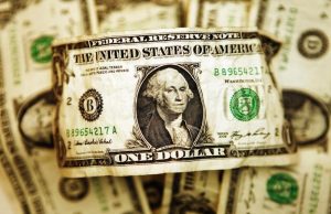 Dollar edges lower, but remains elevated on global growth concerns