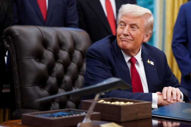 U.S. President Donald Trump signs an executive order in the Oval Office of the White House