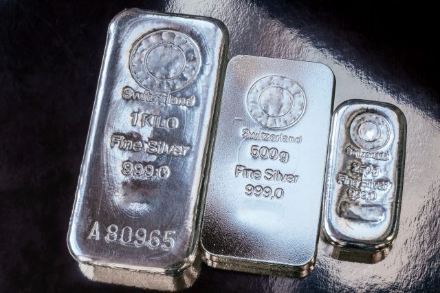 Three silver bars of different weight. The surface of cast silver bullion.